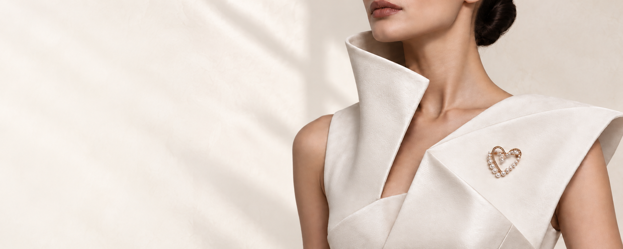 Model wearing the South Sea Heart pearl brooch on a sculptural ivory garment.